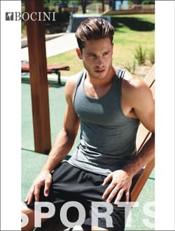 A grey men's athletics singlet featured on a model, paired with black shorts, in an outdoor setting.