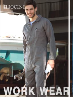 A man wearing a grey cotton drill long-sleeve overall, holding a wrench, with a logo visible.