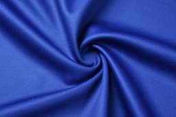 A close-up of a blue, textured fabric, showcasing a swirling pattern with a smooth finish.