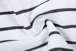 A close-up of white fabric with black horizontal stripes, featuring a smooth, twisted texture.