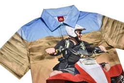 A polo shirt featuring a vibrant desert scene with shades of blue and beige, and a logo on the collar.