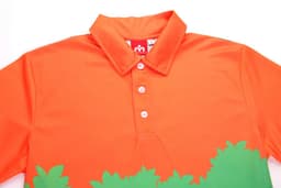 An orange polo shirt with a green foliage design and a collar, featuring buttons and a logo inside the collar.