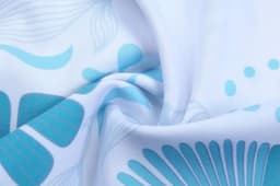 A fabric featuring a floral pattern in light blue and turquoise hues on a white background.