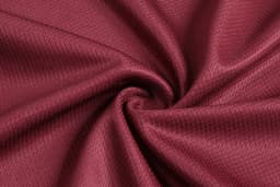 A burgundy fabric with a textured pattern, arranged in a swirl. The fabric appears smooth and lightweight.