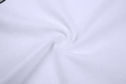 A sleeveless baseball singlet made of white textured fabric, featuring a logo on the design.