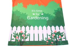 A vibrant green and orange shirt featuring a garden scene with flowers and a white picket fence.