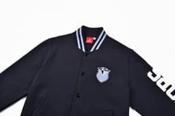 A navy baseball jacket featuring a blue and white logo, with contrasting stripes on the collar and a branded sleeve.