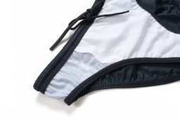 A swimming brief in navy blue and light grey, featuring an anti-chlorine design and a drawstring detail.