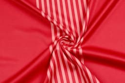A smooth, red fabric featuring subtle vertical stripes, with a glossy finish and a central swirl pattern.