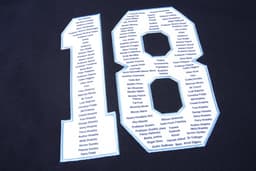 An image featuring a black fabric with a large white number "18" made up of various names listed inside.