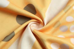 An orange fabric featuring abstract patterns with grey and white dots, showing a soft, textured surface.