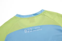 A sailing club t-shirt in green and blue with a branding logo on the back.
