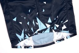 A waterproof woven vest in black with a blue geometric pattern near the hem. It features a logo on the fabric.