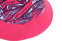 A reversible bucket hat featuring a vibrant pink and patterned design, with a textured brim and a logo.