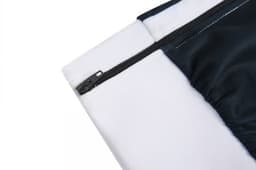 A close-up of a zipped section of a black and white fabric, featuring soft and smooth materials.