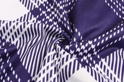 A close-up of fabric featuring a geometric pattern in navy and white. The material is soft and textured.