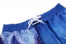 A pair of blue beach shorts featuring a drawstring and a vibrant, abstract pattern.