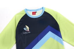A sailing club T-shirt featuring a navy, light green, and blue design, with a logo on the front.