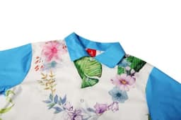 A floral-patterned shirt in white and blue, featuring a blue collar and vibrant botanical designs.