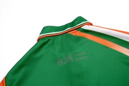 A polo shirt in green with orange and white stripes, featuring a collar and a logo on the back.