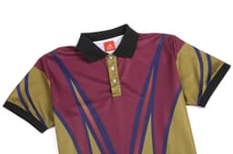A polo shirt featuring a maroon, olive green, and navy design with a black collar and a logo.
