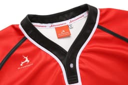 A red rugby tee with black and white trim, featuring a logo on the chest and a branded tag inside the collar.