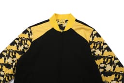 A black and yellow jacket featuring a camo pattern on the sleeves and a zipper front. It includes a logo.