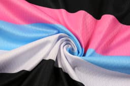 A swirl of fabric featuring stripes in black, white, pink, and blue. The texture displays a sporty pattern with a sheen.