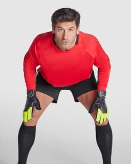 A sporty long-sleeved red t-shirt worn by a goalkeeper, paired with black shorts and gloves.