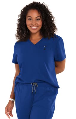 A woman wearing a blue "Ready to Work Top" with a V-neck and a chest pocket, smiling at the camera.