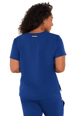 A blue scrub top with short sleeves and a logo on the back, worn by a person with curly hair.