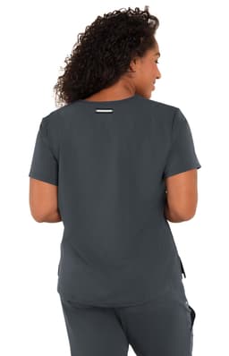 A woman with curly hair wearing a dark grey short-sleeve top, viewed from the back. The top has a logo.