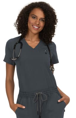 A model wearing a grey medical scrub top, styled with a V-neck and a stethoscope around her neck.