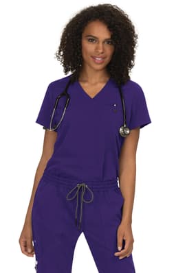 A woman wears a purple v-neck top with a stethoscope around her neck, featuring a logo.