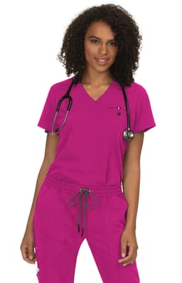 A model wearing a vibrant pink scrub top, accompanied by a stethoscope, with matching pink pants.