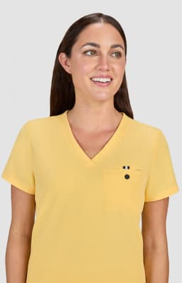 A yellow v-neck top with short sleeves and a small pocket, worn by a woman with long brown hair.