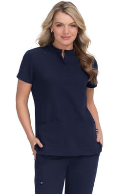 A navy blue medical scrub top worn by a model, featuring a collar and two front pockets. The top is paired with matching pants.