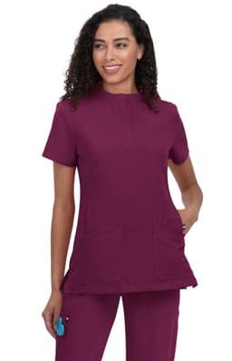 A scrub top in burgundy with a rounded neckline and two front pockets, featuring a branding logo.
