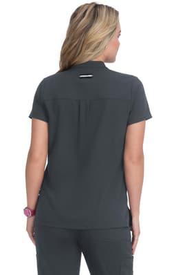 A woman is wearing a short-sleeved, dark grey shirt, viewed from the back. The shirt has a logo on it.