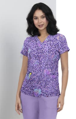 A purple printed top featuring a leopard pattern, with a woman wearing it and posing against a light background.
