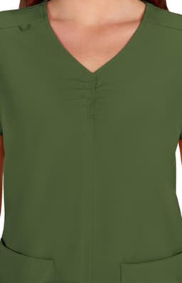 A close-up of a green scrub top featuring a v-neck design and gathered detailing at the front.