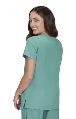 A woman smiles while wearing a teal top with short sleeves, featuring a relaxed fit and side slits.