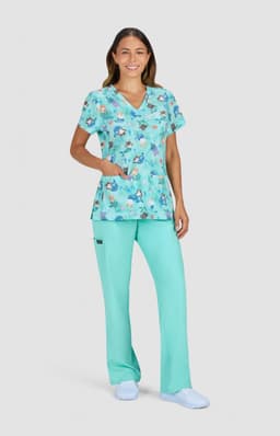 A floral print top in shades of teal, paired with matching teal pants, worn by a woman. The outfit includes a logo.