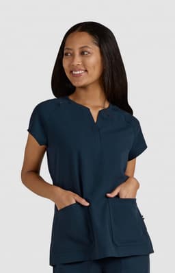 A navy blue medical top with short sleeves, featuring front pockets and a small logo.