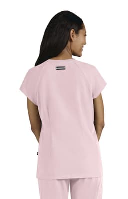 A pink women's top with short sleeves and a simple design, featuring a back detail and a logo.