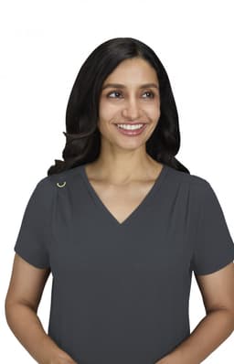 A woman smiles while wearing a charcoal grey Sari Top with a V-neck and short sleeves. The top features a small logo.