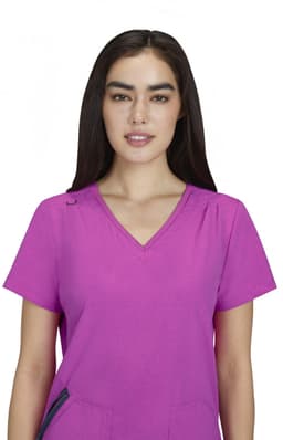 A pink Sari Top featuring a v-neck design and short sleeves, modelled by a woman with long dark hair.