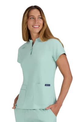 A mint green top with a zip neck and two front pockets, featuring a logo on the side.