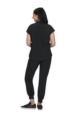 A black women’s outfit featuring a short-sleeve top and tapered pants, with a person standing from the back.