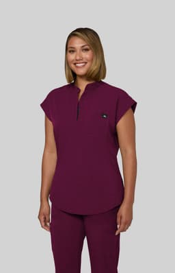 A purple scrub top with a collar and cap sleeves, featuring a logo on the chest.